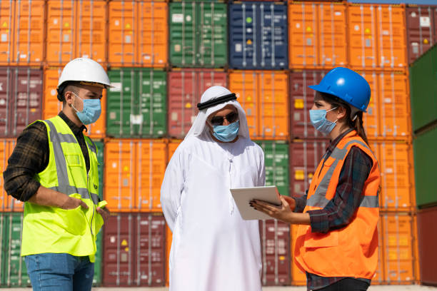 istock Middle Eastern Businessman and engineers with face mask working outside on a large commercial dock during pandemic 1290911708