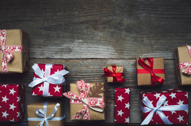 istock Wrapped Christmas presents on a rustic wooden table top view flat lay 1290912848