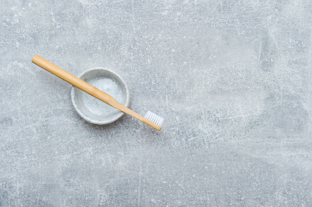 istock Bamboo toothbrush in holder on grey background. Zero waste concept