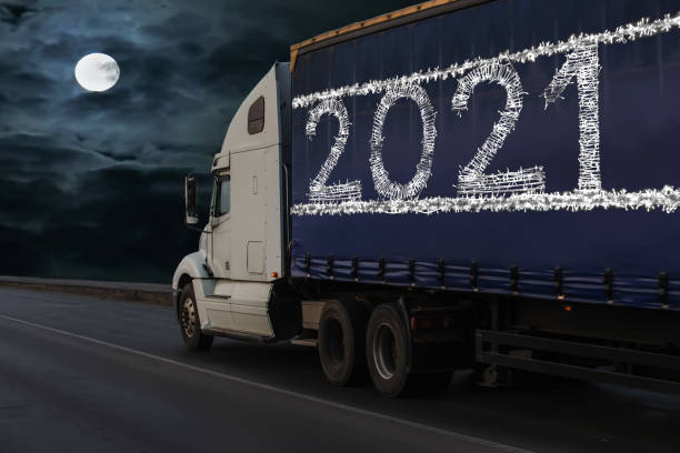 istock truck moving on the road on moonlit night. 1290917111