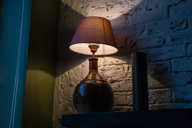 istock Stylish table lamp illuminating a brick wall 1290917171