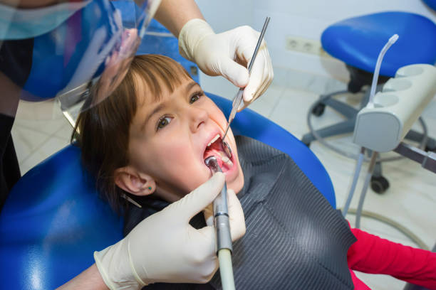 a portrait of a child patient in a dental chair in a dentist’s office - dentist dental hygiene dental assistant dentist office imagens e fotografias de stock