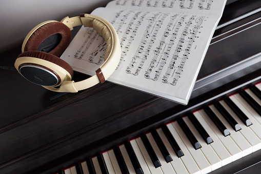 Electrical piano (clavinova) keys, headphones and sheet music