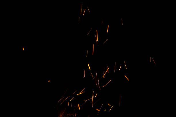 istock Burning red hot sparks fly from large fire in the night sky. Beautiful abstract background on the theme of fire, light and 1290919978