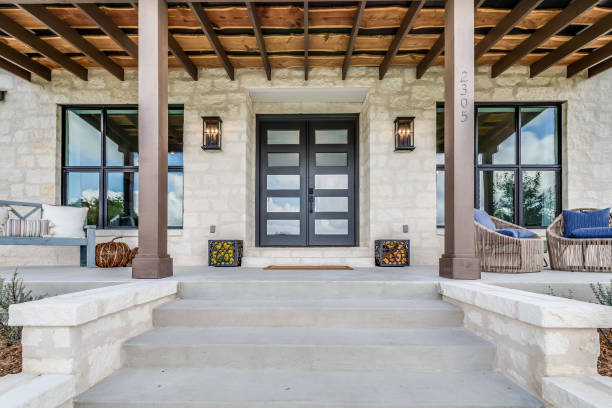 Beautiful front steps leading to grand entrance New home with stone facade and nicely decorated for summer evenings front door stock pictures, royalty-free photos & images