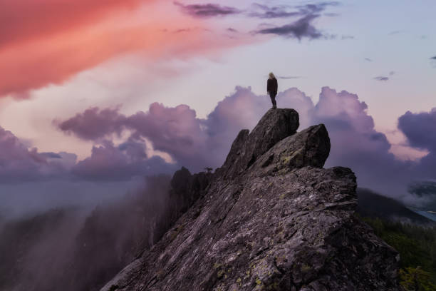 istock Adventurous Girl on top of a Mountain Peak 1290935593