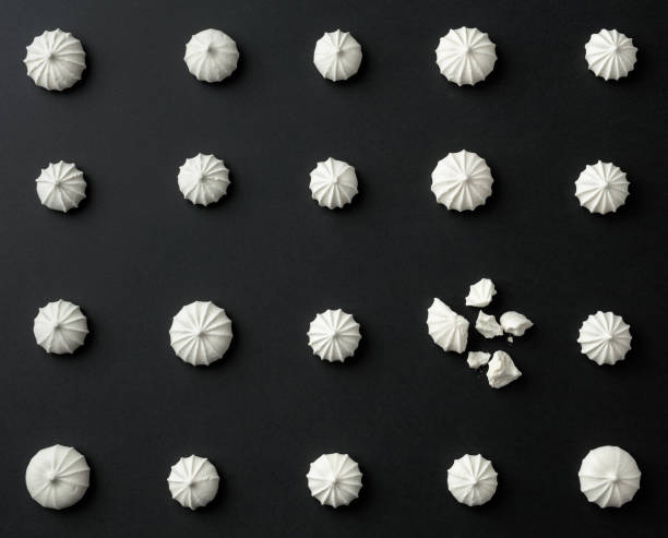 istock Small white meringues on the black table. 1290937999
