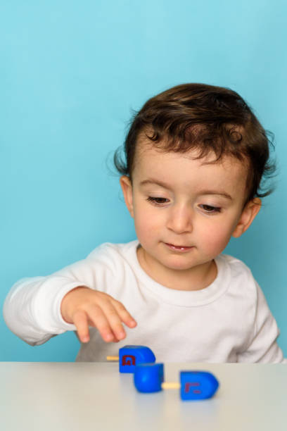 istock Jewish boy playing with dreidel at home 1290955752