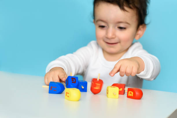 istock Jewish boy playing with dreidel at home 1290956355