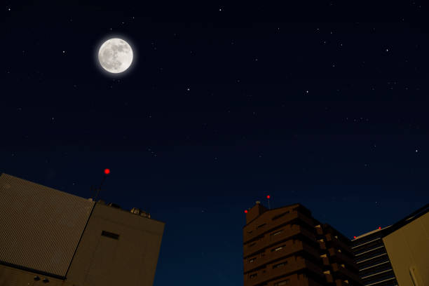 istock Full moon rising over the buildings 1290956563