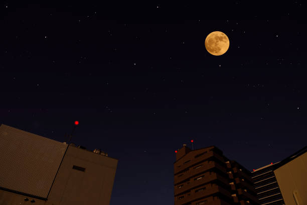 istock Full moon rising over the buildings 1290956573