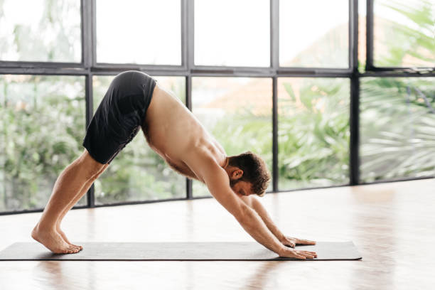 istock Yoga men workout in studio in front of a window 1290958891