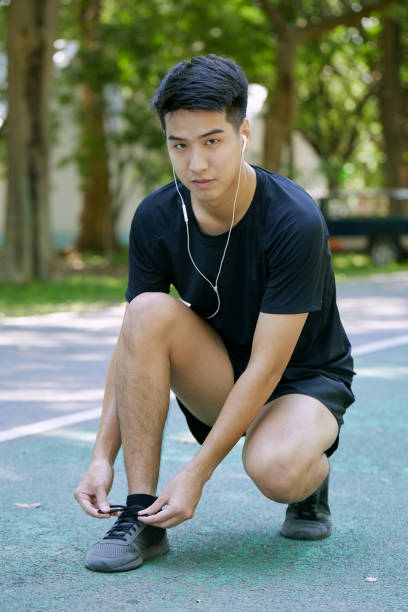 istock Sporty Man Tying Shoelace Before Jogging In Summer Park 1290960463