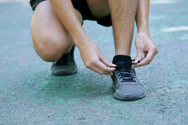 istock Sporty Man Tying Shoelace Before Jogging In Summer Park 1290960469