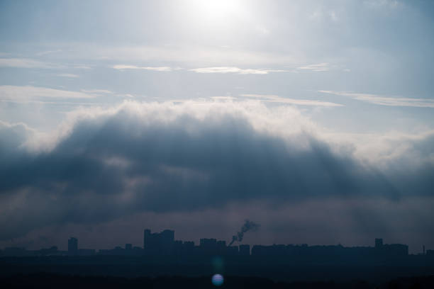 The sun's rays make their way through the clouds over the city skyline