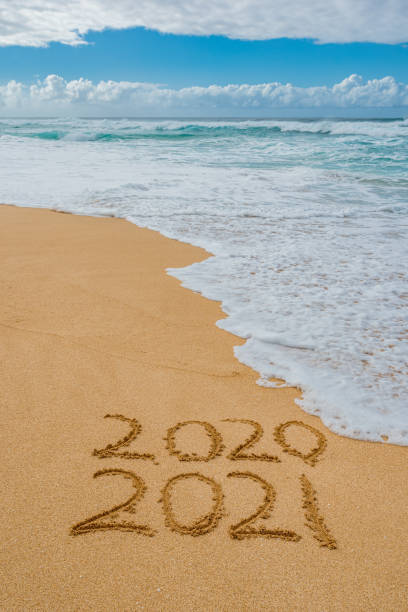 istock 2020 2021 written in the sand with a wave washing away 2020 1290962565