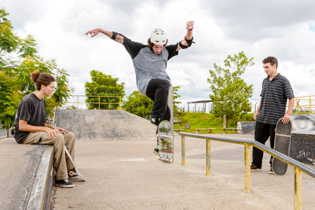 istock Three friends in park performing skateboarding maneuver 1290963207
