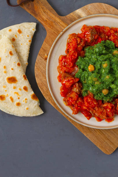 istock Mukimo, Kenya cuisine, meat stew, with chapatis on a dark background, top view, no people, vertical 1290971477