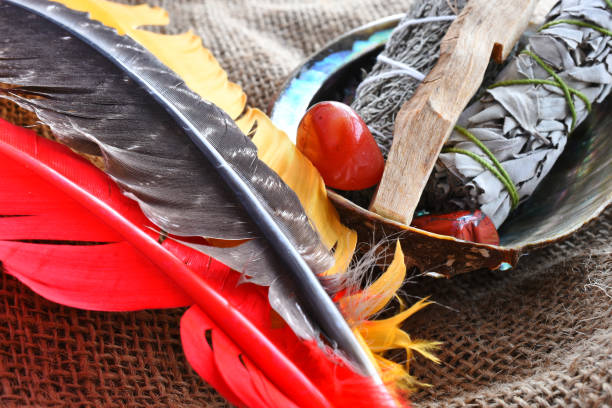 White Sage and Sacred Feathers A top view image of white sage smudge sticks with red jasper healing crystals and a sacred feather on burlap fabric. jasper mineral stock pictures, royalty-free photos & images