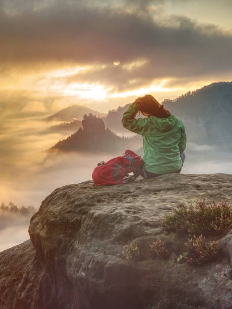 人生を楽しんでいる女性。山の上に座って一日を楽しむ美しい女の子のバックパッカー - climbing mountain climbing rock climbing women ストックフォトと画像