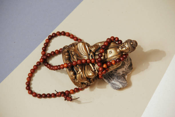 istock Table with occult attributes. Buddha figurine with wooden rosaries 1290975414