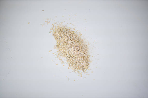 Over head shot of an upside down breakfast bowl with scattered cereal on a red background.