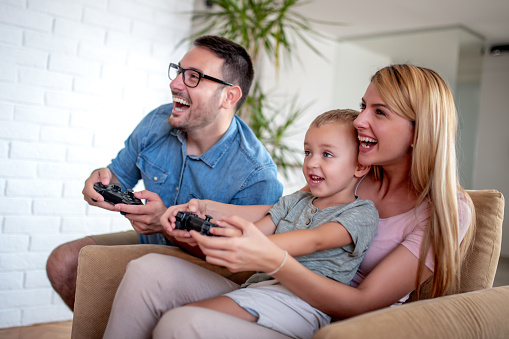 Happy family playing video games in their living room.