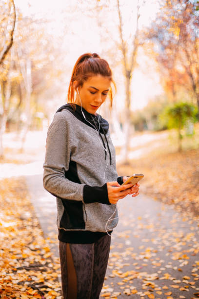 istock Woman Resting After Exercise, Checking Her Smartphone at Park 1290995779