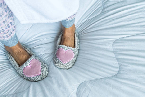 старшая женщина наслаждайтесь воскресенье утром носить уютные розовые тапочки - slipper senior adult shoe human leg стоковые фото и изображения