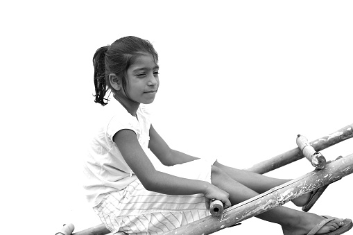 Elementary schoolgirl sitting on ladder against white background.