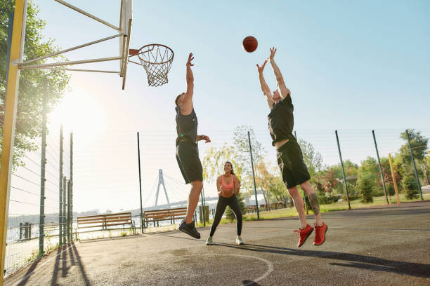 istock Cheerful athletic people spending time together outdoors on playground, playing basketball on a sunny day 1290998099