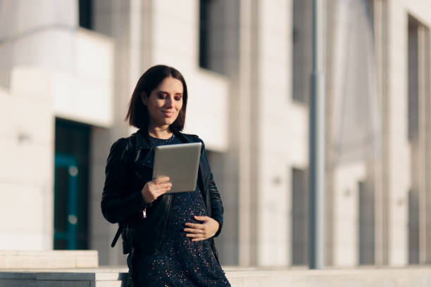 istock Happy Pregnant Woman Holding a PC Tablet 1290999954