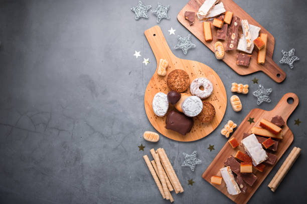 dulces tradicionales de navidad españoles turron, polvorones, mantecados con decoración navideña en mesa gris, espacio de copia - torrone fotografías e imágenes de stock