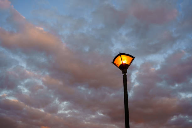istock street lamp on the background sunset dark sky rolled with clouds. 1291000673