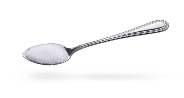 соль в ложке из нержавеющей стали на белом фоне - sugar spoon salt teaspoon стоковые фото и изображения