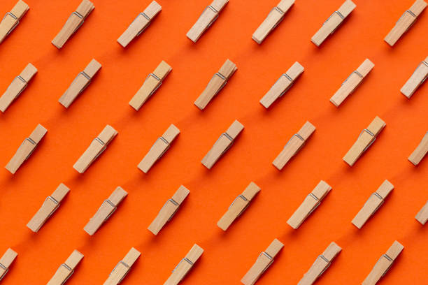 istock Many wooden clothespin on orange background. 1291004251