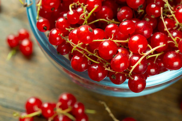 istock Sweet fresh red currant in a plate on wood table. 1291004356