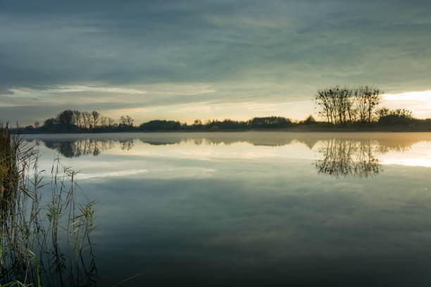 istock Fog on a quiet lake and evening clouds 1291007352