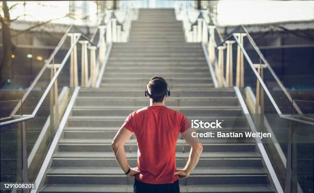 Man In Red Shirt Preparing For Stair Run Stock Photo - Download Image Now - Motivation, Staircase, Aspirations