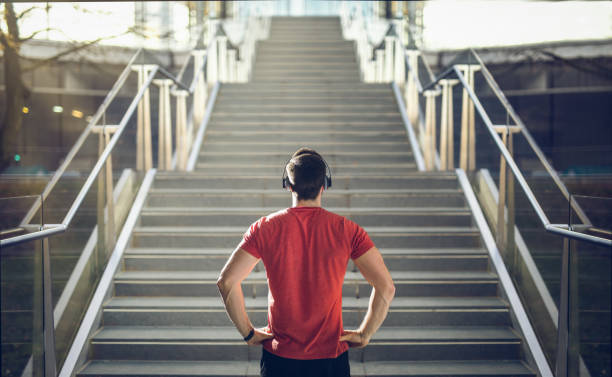 mężczyzna w czerwonej koszuli przygotowuje się do biegu schodów. - motywacja zdjęcia i obrazy z banku zdjęć