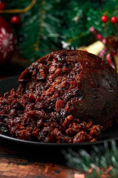 istock Christmas pudding with decoration, gifts, green tree branch on wooden rustic table 1291008445