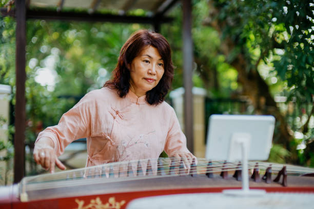 istock Senior woman using digital tablet for online Guzheng class 1291012499