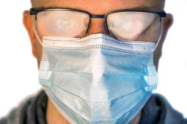 istock man with fogged glasses through face mask 1291015542