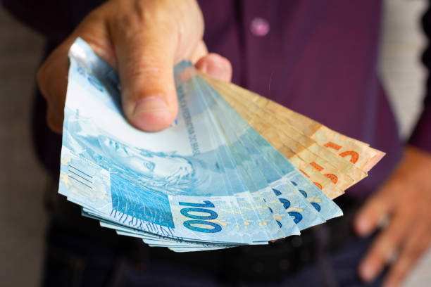 istock Older man displaying a spread of cash 1291016979