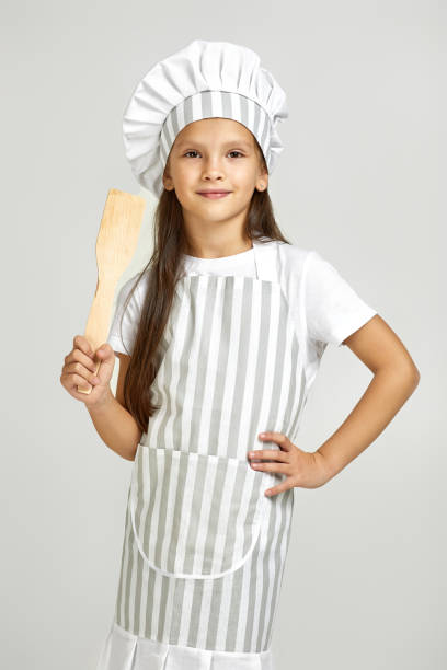 istock cute little girl in chef hat and apron 1291018070