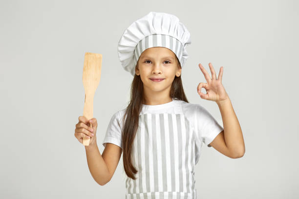istock cute little girl in chef hat and apron 1291018379