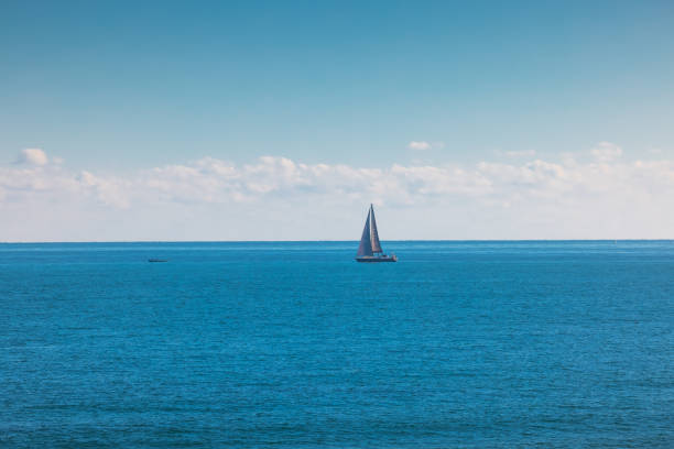 istock Sea and sailing wind boat. Sailboat over blue waves and sunny sky 1291020021