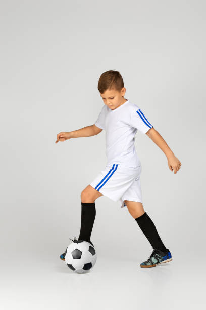 kleines kind junge im outfit spielen mit fußball - soccer child indoors little boys stock-fotos und bilder