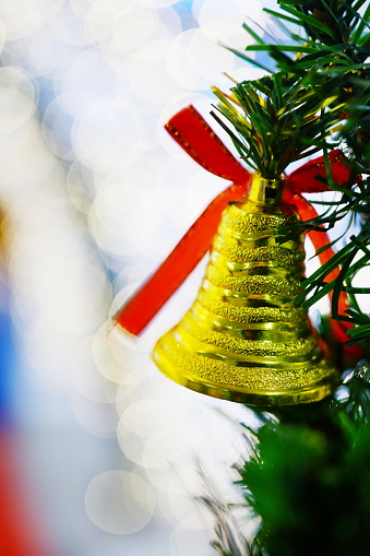 Close-up Christmas bells hanging on christmas tree and light