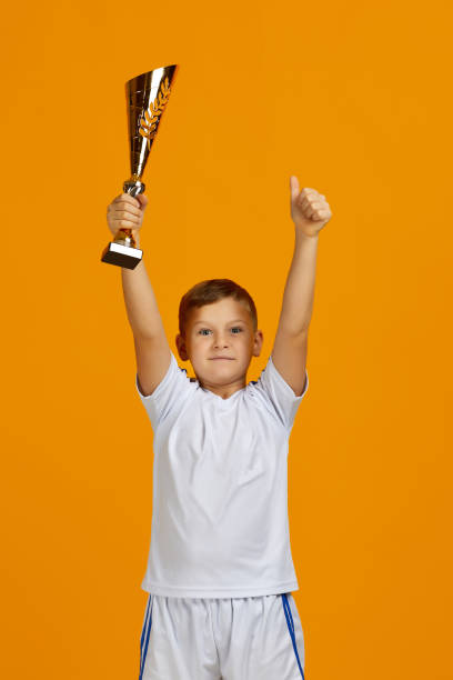 istock Football player holding a golden cup 1291025171